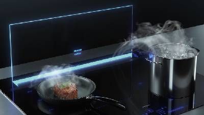 Una cucina elegante con una padella con carne sfrigolante e una pentola con acqua in ebollizione, entrambe con vapore, su un moderno piano di cottura a induzione.
