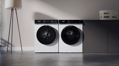 Máquinas de lavar e secar roupa Siemens em branco elegante, com portas pretas grandes e indicações digitais.