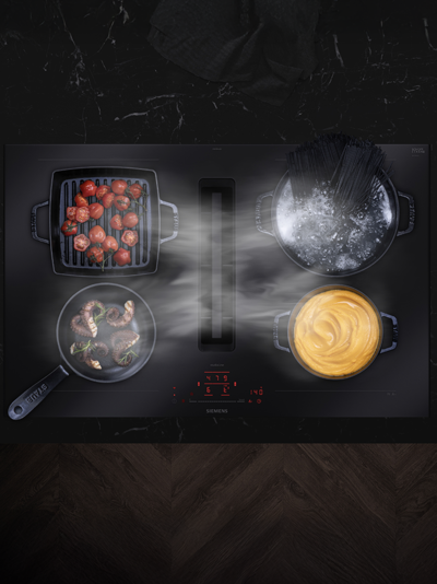 Pohled zeshora na varnou desku s flexZone, na které jsou hrnce a pánve s jídlem.