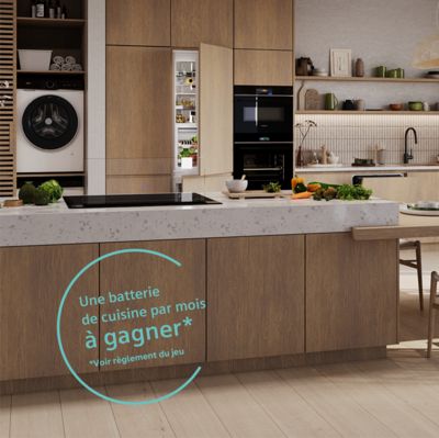 Cuisine moderne avec des armoires en bois et des appareils électroménagers élégants, avec une table à manger et une promotion pour un cadeau d'ustensiles de cuisine.
