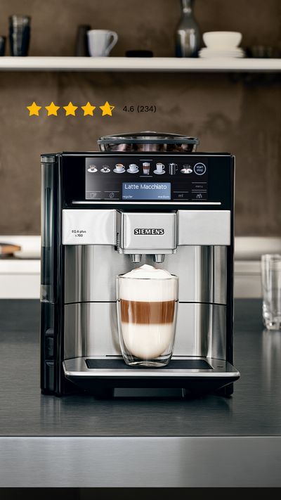 Ein Siemens EQ6 plus Kaffeevollautomat steht neben verschiedenen Kaffeespezialitäten auf einer grauen Küchenarbeitsplatte.