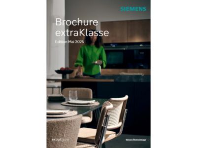 Une scène de cuisine moderne avec un ensemble de table élégant pour les repas, mis en valeur par une brochure de la série extraKlasse de Siemens.