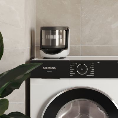 Siemens Hausgeräte iQ700 Waschmaschine mit Mirkoplastikfilter darauf stehend