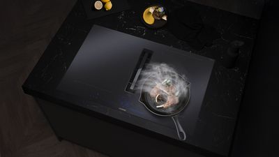 Mat sort Induction Air Plus induktionskogeplade i mørke møbler, stegepande på kogepladen.