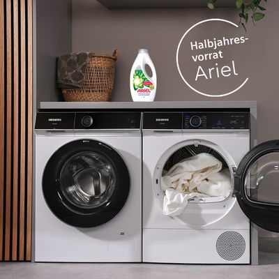 Ariel Flüssigwaschmittel steht auf Siemens Waschmaschine in einer schönen Waschküche und daneben steht der Hinweis auf einen gratis Halbjahresvorrat Waschmittel im Siemens Online Shop