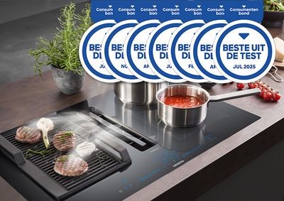 Keuken met grill en pannen, steaks en sauzen. Meerdere "Best in Test"-prijzen zichtbaar.