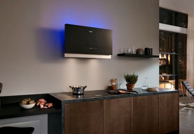 Campana extractora Siemens en cocina moderna con iluminación azul y encimera de mármol verde oscuro.