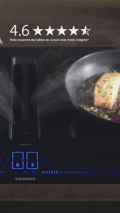 Poêle à vapeur sur le plateau de cuisson à induction, avec tranche de citron et de crampons de romarin.
