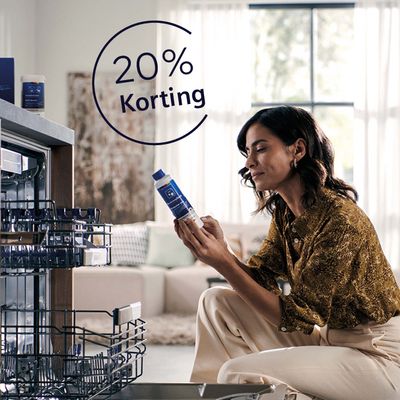 Vrouw zittend voor geintegreerde Siemens vaatwasser met reinigingsmiddel in haar hand, ook icoon met 20% korting.   