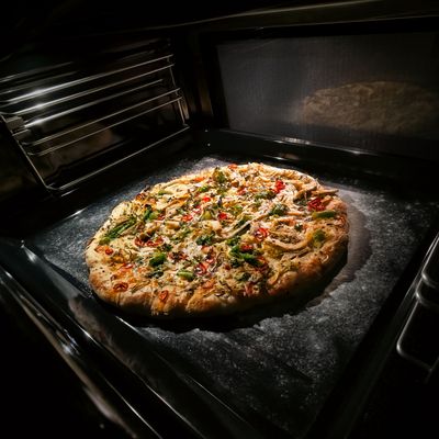 Un four Siemens avec une caméra intégrée montrant une pizza en cours de cuisson.
