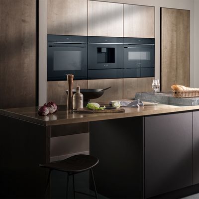 Ovens in kitchen cabinetry with pan and ingredients on counter