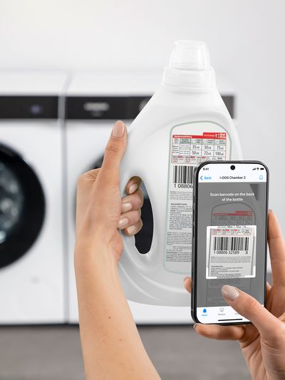 Der Barcode eines Waschmittel-Behälters wird von einer Person mit einem Smartphone eingescannt.