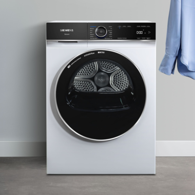 Eleganter weißer Wäschetrockner mit Bedienfeld und offene Tür, auf Betonboden stehend. 