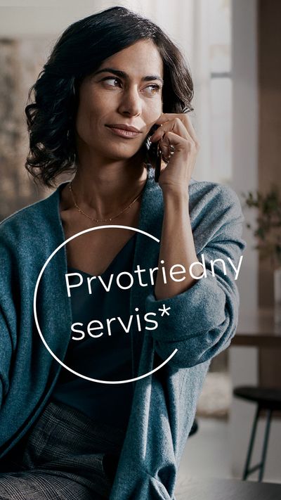 Usmievaj&uacute;ca sa žena v modrom kardig&aacute;ne, ktor&aacute; telefonuje v &scaron;t&yacute;lovom domove