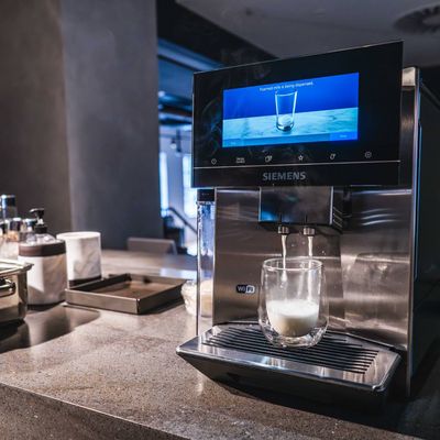 A coffee machine with milk being poured into it, ready to create a creamy beverage. 