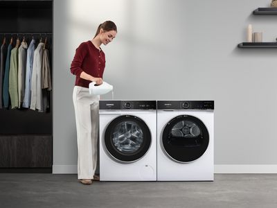 Kobieta dolewa plynu do pralki