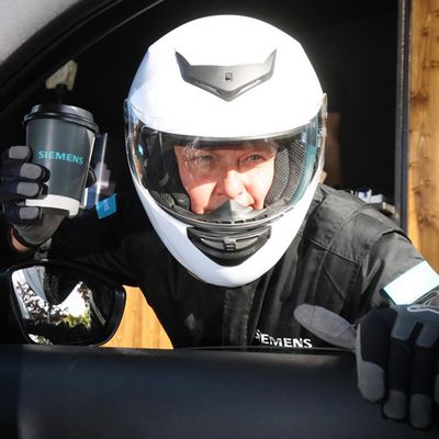 Racing driver holding a siemens coffee cup