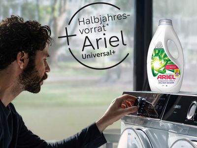 Mann r&auml;umt W&auml;sche in Siemens Waschmaschine mit Hinweis auf Ariel Halbjahresvorrat Aktion