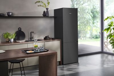 Cuisine moderne  avec des nuances de gris et de noir. le seul appareil &eacute;lectrom&eacute;nager visible est un  un r&eacute;frig&eacute;rateur noir. 