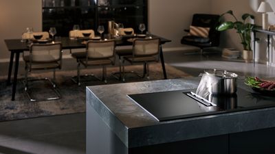 Open kitchen dining area with vented induction hob in use