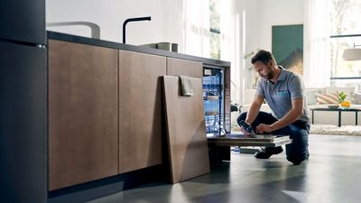 Siemens engineer working on dishwasher in kitchen