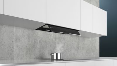 Cucina moderna con cappa Siemens integrata nel pensile, posizionata sopra il piano a induzione con pentola e vapore