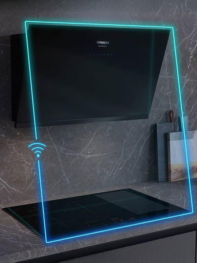 Modern kitchen features a sleek black Siemens induction cooktop with illuminated edges and a stylish hood above, set against marble walls.