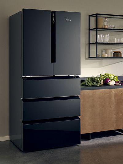 A stylish black Siemens refrigerator with a sleek design and multiple drawers, set against a modern kitchen backdrop.