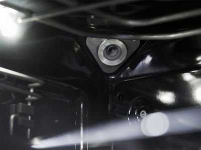 Close-up of a clean, dark oven interior with a silver temperature probe connection point.