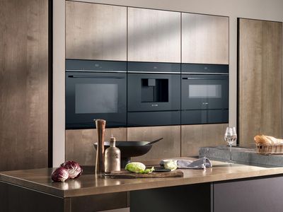 Nowoczesna kuchnia z eleganckimi, czarnymi urządzeniami piekarnik, ekspres, mikrofala i szuflady grzewcze Siemens