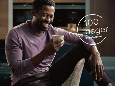 Mann sitter i en stol og holder en kaffekopp. &Oslash;verst i bildet er det et ikon for &laquo;100 dager pr&oslash;v hjemme&raquo;.