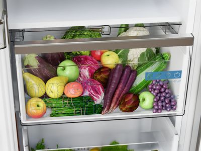 Un cassetto del frigorifero con frutta e verdura di ogni genere: mele, uva, broccoli e zucchine.