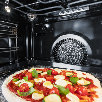 Pizza mit frischen Zutaten im Garraum eines Siemens iQ700 Backofens mit integrierter Kamera.