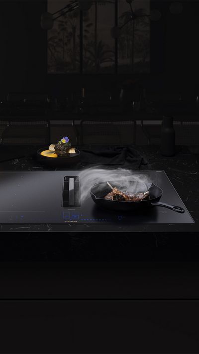 Siemens inductionAir Plus Matt Edition cooktop with integrated extractor in elegant black, operating with steam extraction.