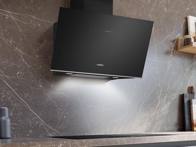 Czarny okap nad nowoczesnym blatem, para unosząca się z garnka na kuchence indukcyjnej, minimalistyczne wnętrze.