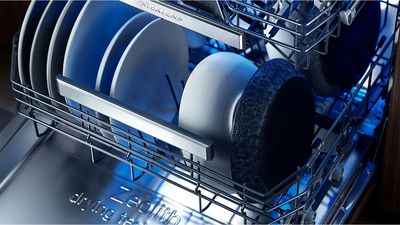 Siemens dishwasher with door open showing dishes inside