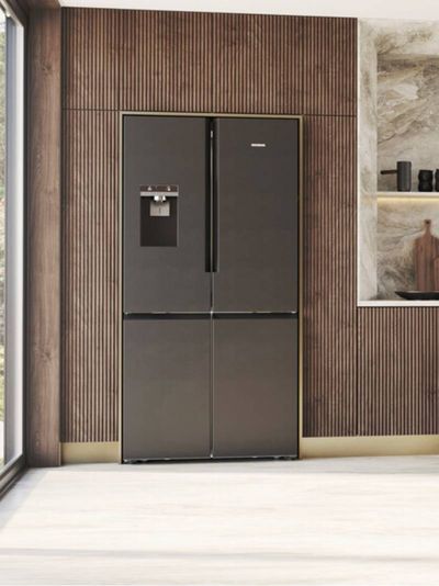A dark grey Siemens French door refrigerator with an external ice and water dispenser, integrated into a modern kitchen with wooden slatted walls and large windows.