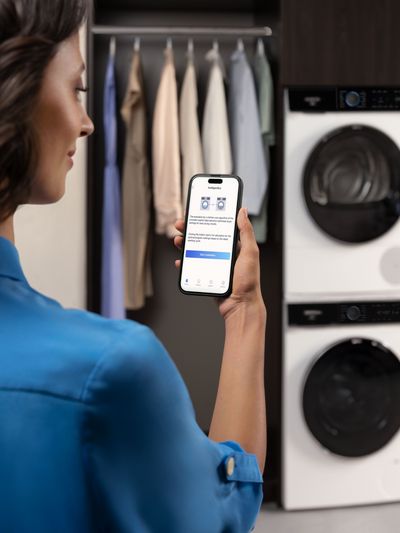 Person using app to control Siemens smart laundry appliance