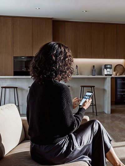Person using app to control smart coffee machine