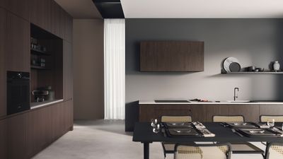       Cuisine moderne avec cuisson sur plaque de cuisson dans une po&ecirc;le &agrave; frire, aliments fumants, citrons sur un plateau et une table &agrave; manger dress&eacute;e en arri&egrave;re-plan.     