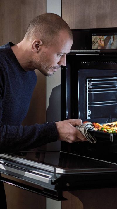 Person checking on food cooking in oven
