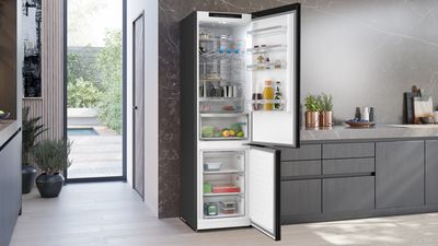 Frigorifero combinato da libera installazione Siemens con porte aperte, che mostra alimenti organizzati nei ripiani