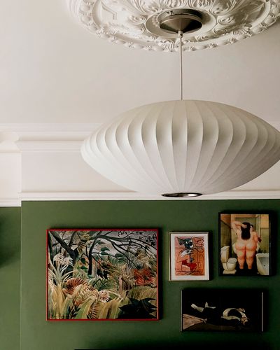 A retro lamp in front of maximalist paintings