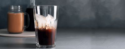 Kubek z kawa coldbrew na drewnianym blacie