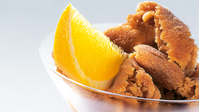 Gros plan sur le haut d'un verre contenant un granit&eacute; &agrave; l'expresso avec une tranche d'orange.