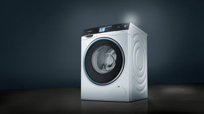 Eine weiß-schwarze Siemens Waschmaschine vor einem schwarzen Hintergrund