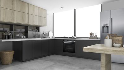 Una cucina moderna progettata in diverse tonalità di grigio e dotata di elettrodomestici di alta qualità.