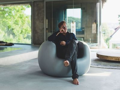 Arno Brandlhuber sitting on concrete-style chair