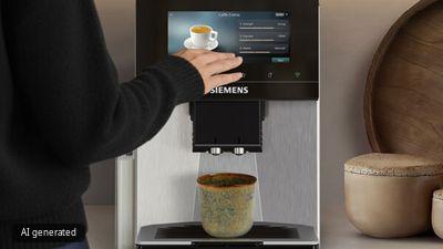 A sleek, modern coffee machine with a touchscreen display sits on a countertop against a muted wall background.