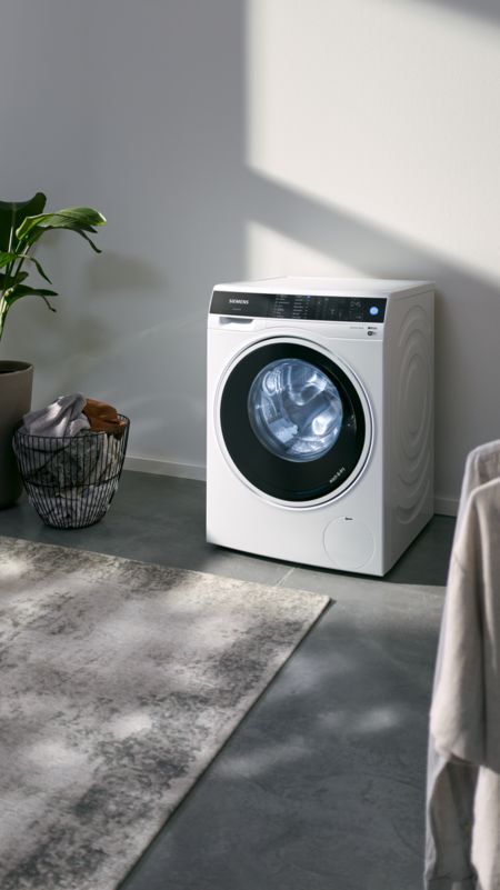 Ein Siemens Waschtrockner steht in einer Waschküche.